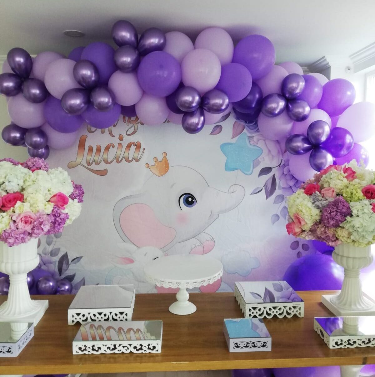 Elegante Decoración de Bautizo Un Toque de Sofisticación con globos en fiesta de bautizo con grandes bombas de color morado lila morado oscuro en mesa de madera