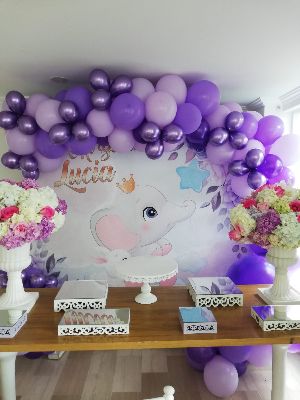 Elegante Decoración de Bautizo Un Toque de Sofisticación con globos en fiesta de bautizo con grandes bombas de color morado lila morado oscuro en mesa de madera